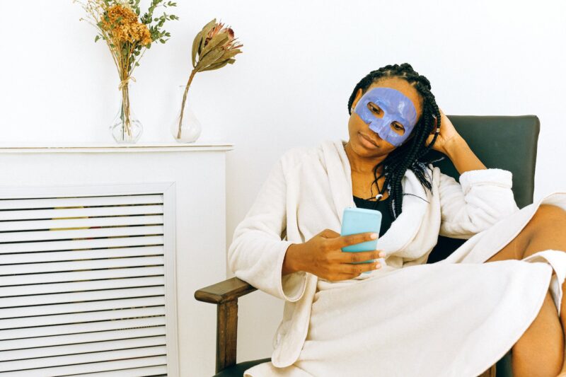 woman in white towel with a skincare mask on her face